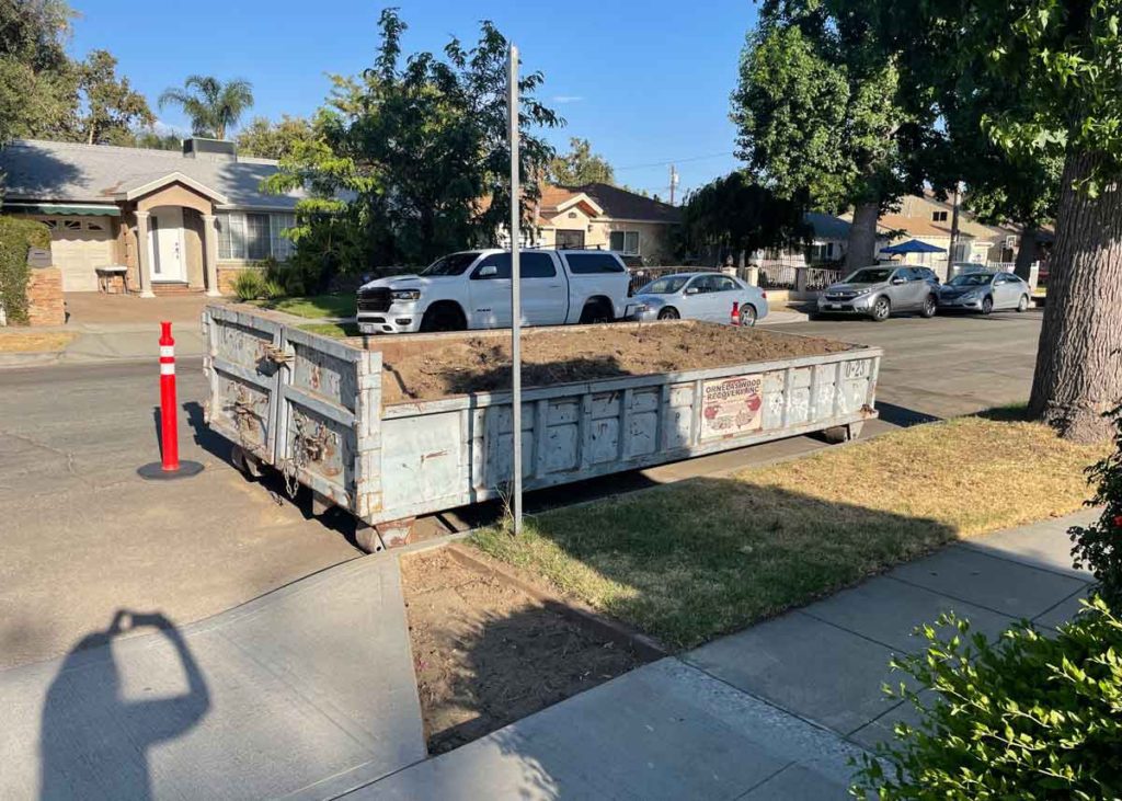 Dumpster full of removed soil for native garden